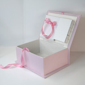 Medium pink seersucker check baby memory box shown open with fabric-lined interior and inner compartments tied with a pink satin ribbon