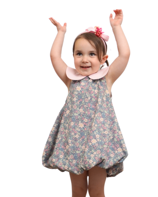 little girl wearing bubble dress gray garden