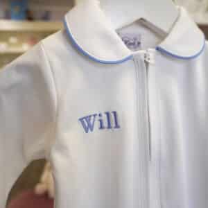 White Pima cotton baby footie with blue-trimmed Peter Pan collar and front zipper.
