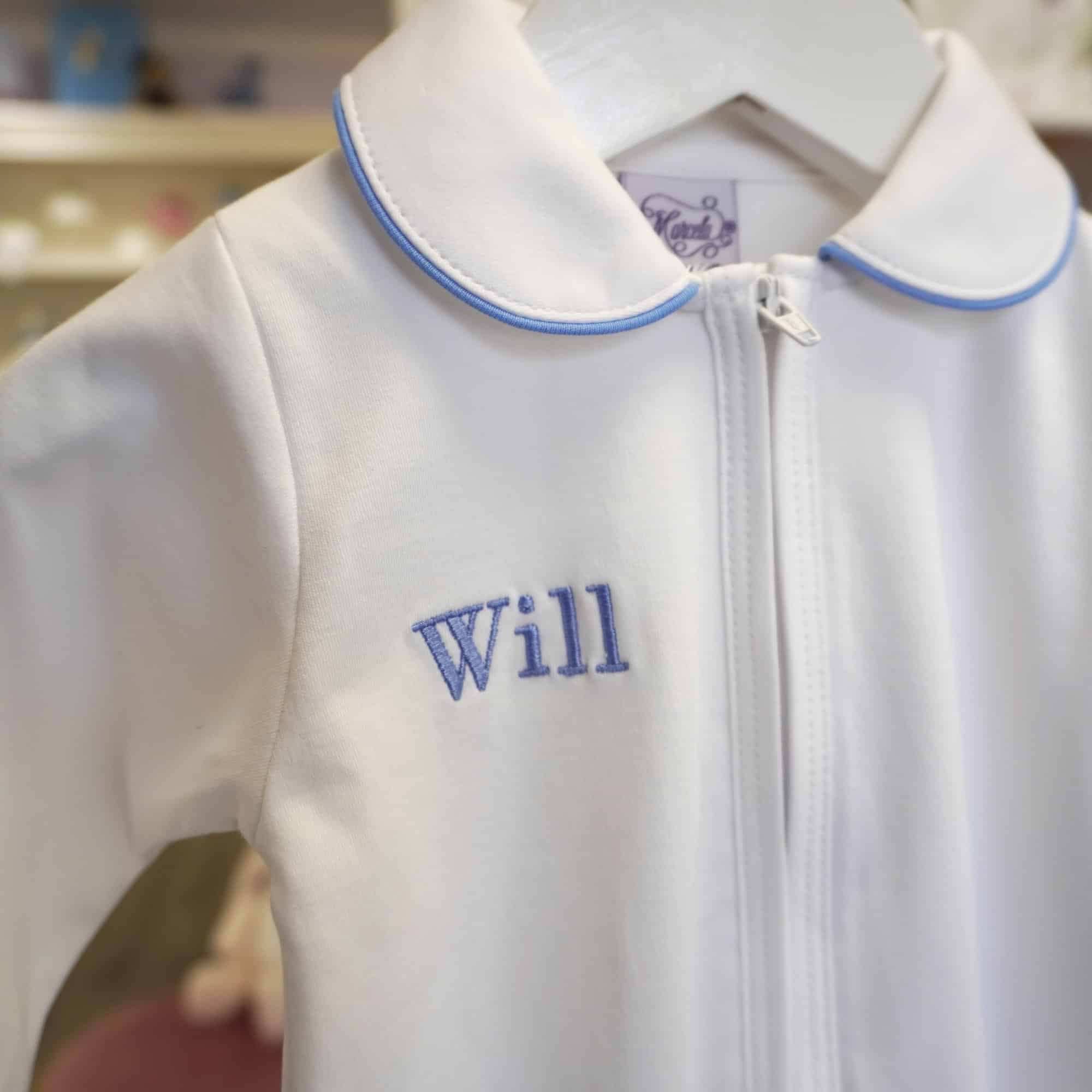 White Pima cotton baby footie with blue-trimmed Peter Pan collar and front zipper.