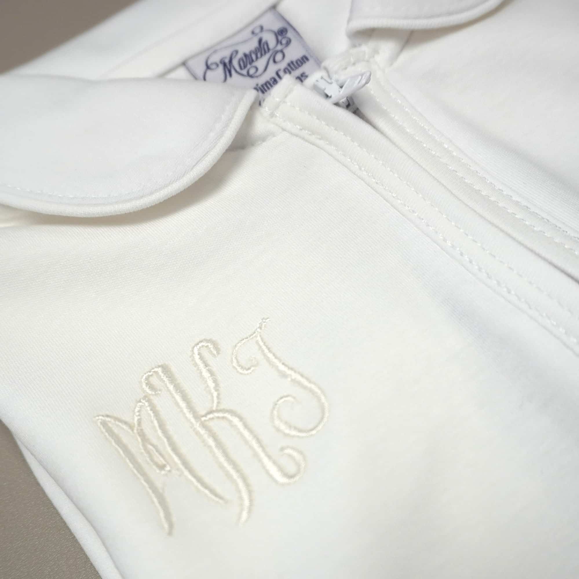 White Pima cotton baby footie with white-trimmed Peter Pan collar and front zipper.